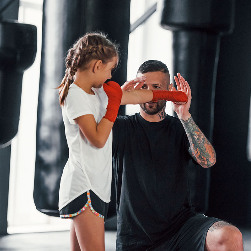 Grundtraining beim Kinder-Kickboxen mit einem Mädchen